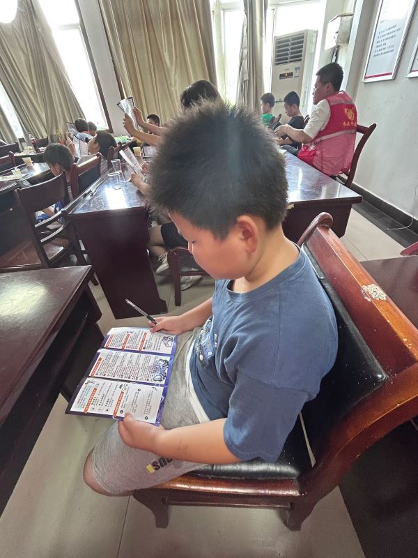 圖為小朋友閱讀網(wǎng)絡(luò)安全健康手冊(cè)